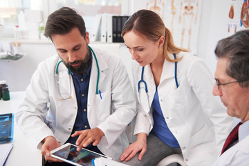 Three doctor working with tablet in doctorâ€™s office