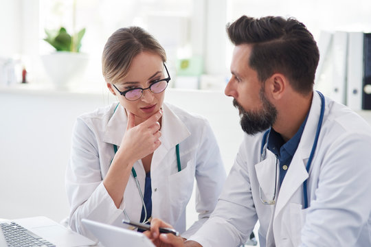 Two busy doctors talking in doctorâ€™s office