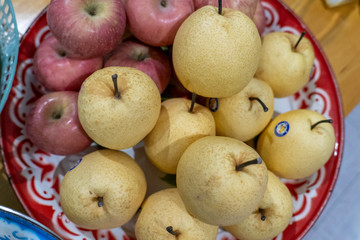 Red apples and honey barrow placed on a tray.