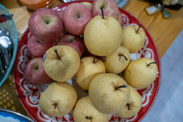 Red apples and honey barrow placed on a tray.