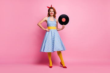 Full size photo of elegant lady old fashion vinyl cd record hands vintage retro theme party event wear dotted dress red high-heels yellow tights isolated pink color background
