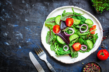 Healthy salad, leaves mix salad (mix micro greens, cucumber, tomato, onion, other ingredients). keto or paleo diet top concept, food background copy space for text
