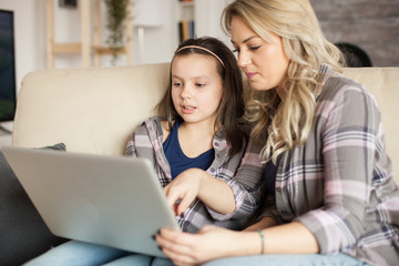 Mother and daughter using laptop with wireless technology