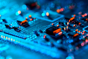 Electronic circuit board with electronic components such as chips close up. Blurry background.