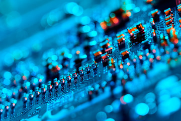 Electronic circuit board with electronic components such as chips close up. Blurry background.