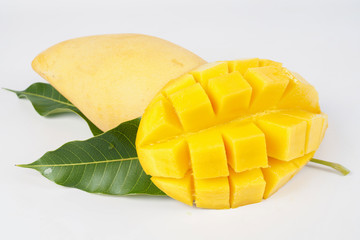 Ripe mango with green leaf of mango on white background, cut in cubes