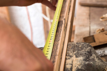 Male carpenter working on old wood in a retro vintage workshop.