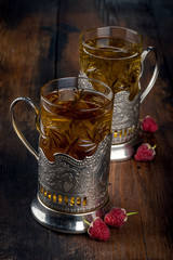 Tea in a glass mug inserted in an iron cup holder