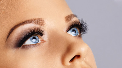 Woman eyes with long eyelashes and smokey eyes make-up. Eyelash extensions, makeup, cosmetics,...