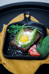 Avocado sandwich with fried egg. Egg on toasted bread for healthy breakfast or snack, copy space. Vegan avocado sandwiche top view close-up