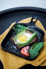 Avocado sandwich with fried egg. Egg on toasted bread for healthy breakfast or snack, copy space. Vegan avocado sandwiche top view close-up