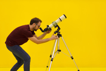 Amateur astronomer looking at the stars with a telescope. Astronomy and astrology concept. Studio...