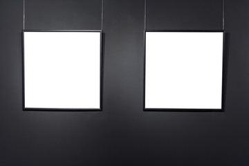 Empty square frames on black brick wall. Blank space posters or art frame waiting to be filled. Square Black Frame Mock-Up