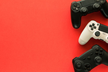 Stock photo of three gamepads on a red background and copy space
