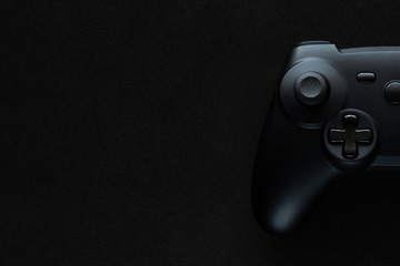 Stock photo of a gamepad on a textured black background and copy space