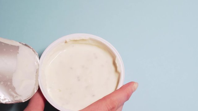 Eco-friendly curd cream with in coconut milk. Female hands tear off the lid from a jar of curd cream. Copyspace for your text
