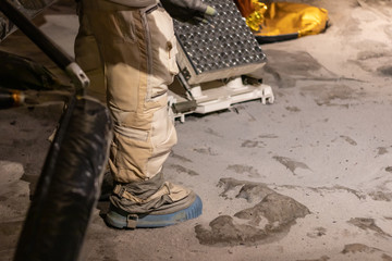 Spacesuit details and close up of rubber boots.Moon landing simulation in lab. Lunar soil, Nasa technology, cosmic travelling concept. 