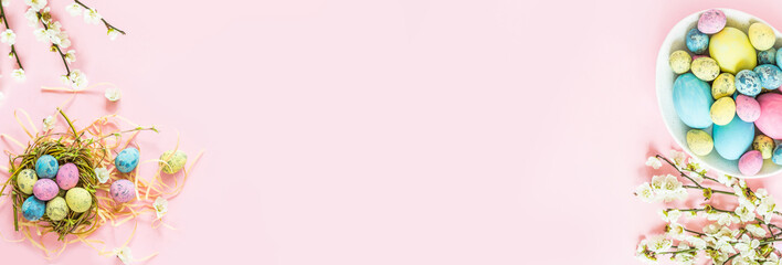 Stylish background with colorful easter eggs isolated on pink pastel background with blooming...
