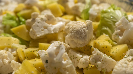 Vegan food, close-up of pan of raw vegetables sliced like ratatouille with cauliflower and potatoes oregano and rosemary before being cooked
