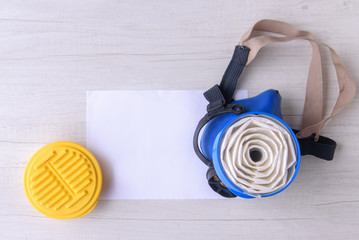 Respirator isolated on a wooden background. Face-guard. Mask for repair work. white sheet of paper....