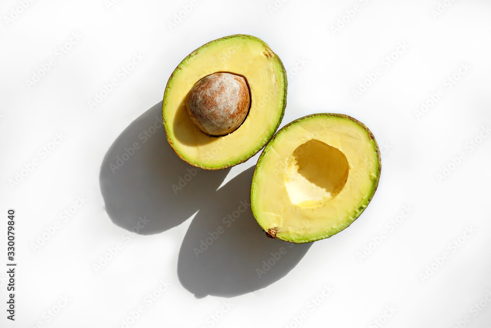 Wall mural a fresh avocado cut in half on white background