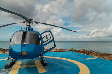 Blue Helicopter for excursion tour on parking near beach in George Town,Cayman island. Helipad is...