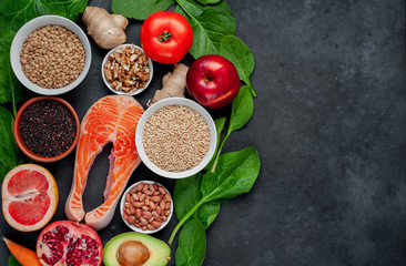 Fototapeta na wymiar Selection of healthy food: salmon, fruits, seeds, cereals, superfoods, vegetables, leafy vegetables on a stone background with copy space for your text. Healthy food for people.
