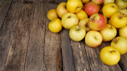 Naklejka na ściany i meble A lot of ripe yellow apples on a old wooden table. Place for text.