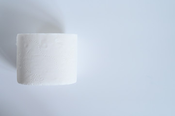 rolled white toilet paper in a white background. space for text, flat lay, top view