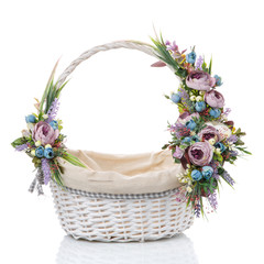 Fototapeta na wymiar Wicker basket with flowers and ribbons. Beautiful floral decor on the side on the basket handle. Isolated