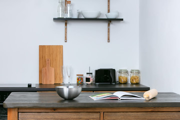 The interior of a simple kitchen. Kitchen table with a bowl and a book.