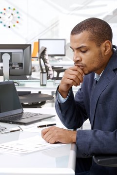 Serious black businessman thinking hard at office