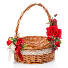 Fototapeta na wymiar Easter basket made of natural vines with handmade decor in red. Basket with floral decoration on white background