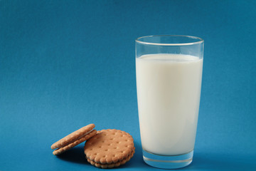 cookies and a glass with milk. cookies with cream on a blue background
