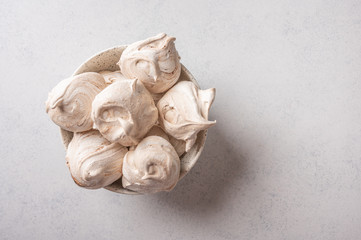 Homemade popular dessert meringue on a vase on a white wood table