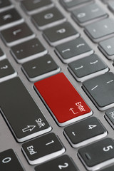 Laptop keyboard macro close up fading red enter key