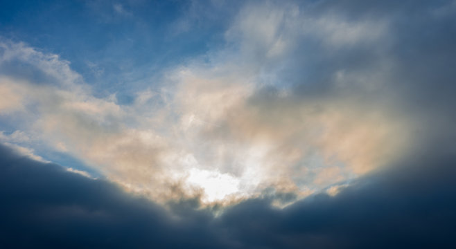 Dramatic cloudscape Sun piercing through the clauds