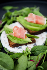 Avocado sandwich with jamon. Toasted bread for healthy breakfast or snack, copy space. Spanish tapas. Italian brushetta. Vegan avocado sandwich top view close-up