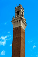 Fototapeta premium Siena (SI), Italy - June 01, 2016: Mangia tower in the old town of Siena, Tuscany, Italy