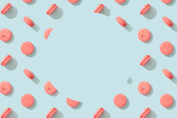 Colorful pattern cakes macaroon on blue pastel background with copy space in circle shape. French almond cookies dessert, top view. Wrapping paper, poster, greeting card, cover, sale background