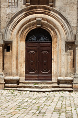 Fototapeta premium Montepulciano (SI), Italy - June 01, 2016: Cobblestone pavement leading to front door of Community Building in Piazza Grande, Montepulciano, Tuscany, Italy