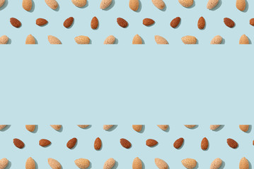 Almonds flat lay pattern with copy space. Whole and peeled almond nuts. Top view. Wrapping paper, poster, greeting card, cover, sale background