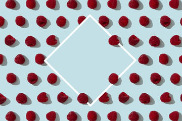 Raspberries pattern on blue background with copy space in rhombus shape. Wrapping paper, poster, greeting card, cover, sale background. Top view