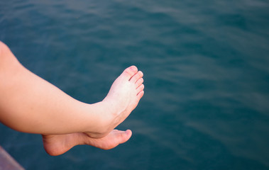 Female legs relaxing by the pool from above