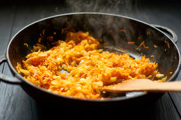 Fry onions and carrots in a pan.