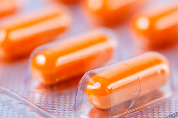 orange pills capsule medicine and pharmacy macro blur background