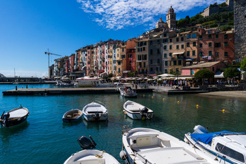 Portovenere La Spezia Italy coloured building in the old town sen from the pier with small boats on a sunny summer day © Octavian
