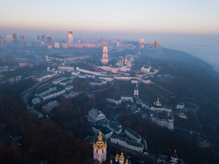 Aerial view Kyiv Pechersk Lavra churches on hills from above with morning fog, Ukraine