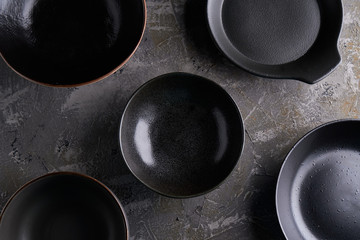 background of black plates on a dark table Top view
