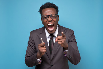Laughing african american man is laughing on your joke over blue background. Studio shot